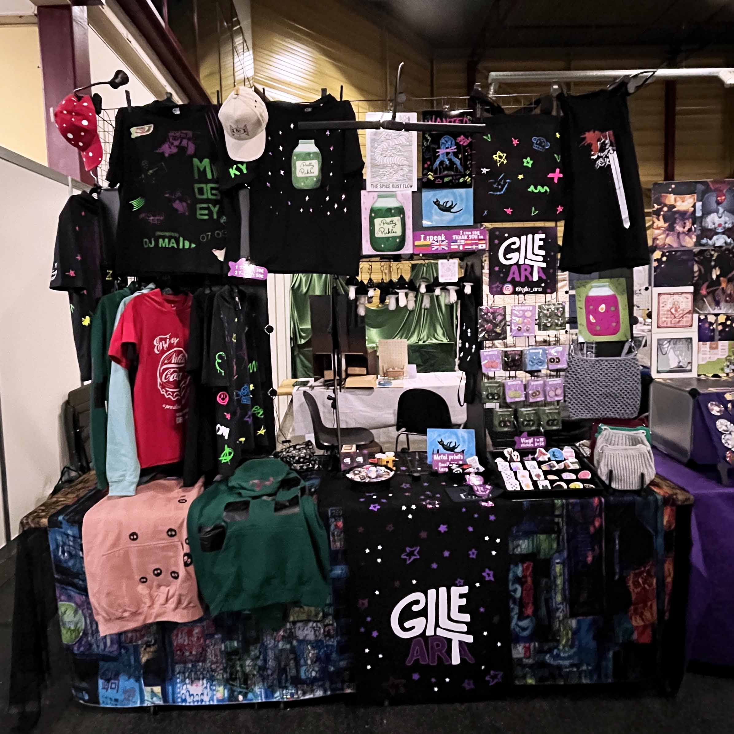 Artisanal clothing and product display with 'Gile Art' branding.