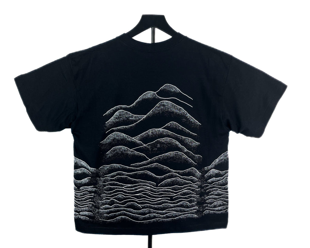 A black short-sleeve t-shirt with layered soundwave-style hills.