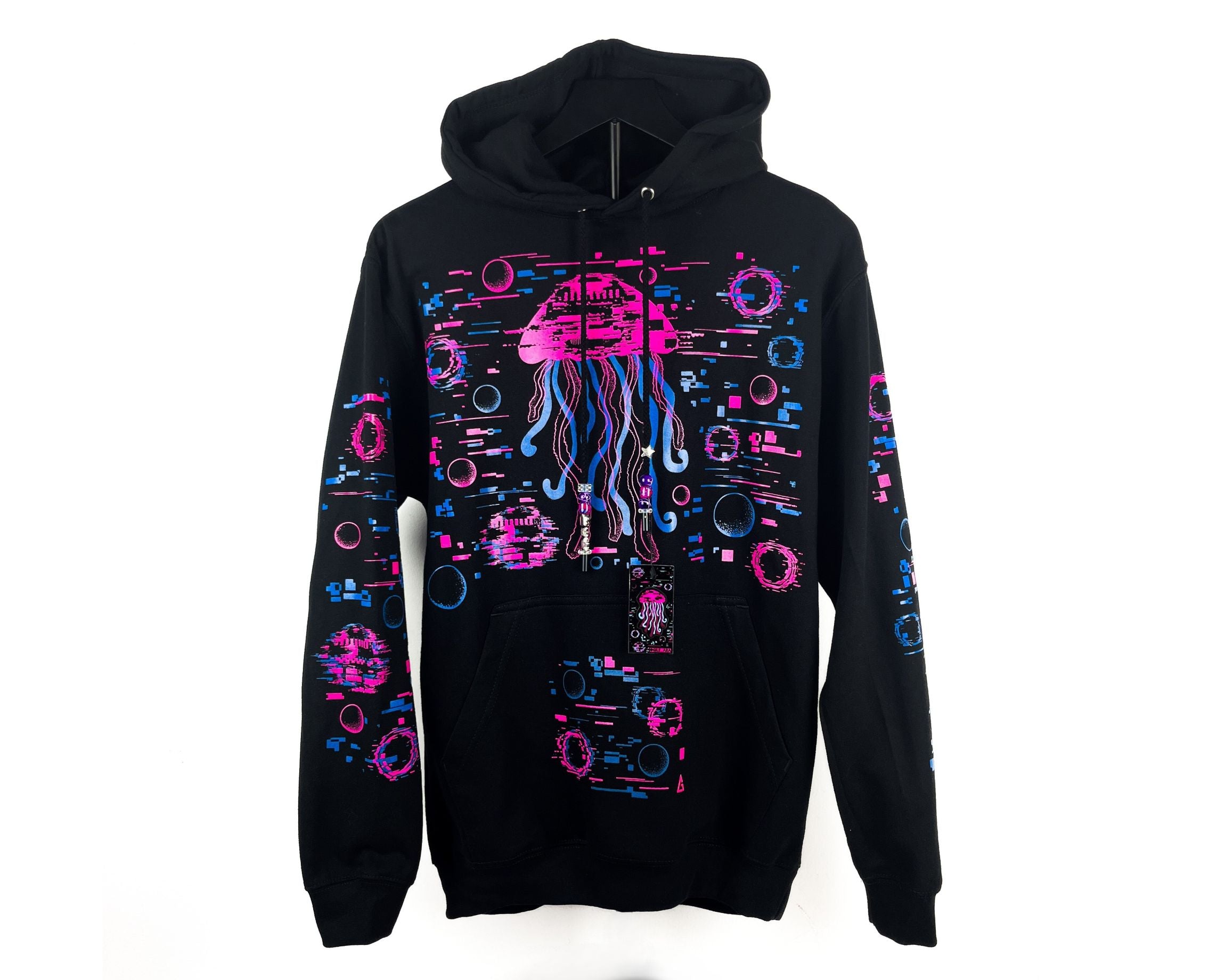 A black pullover hoodie featuring a vibrant neon pink and blue graphic print of a jellyfish and various abstract geometric patterns on the front and sleeves, displayed against a plain white background.