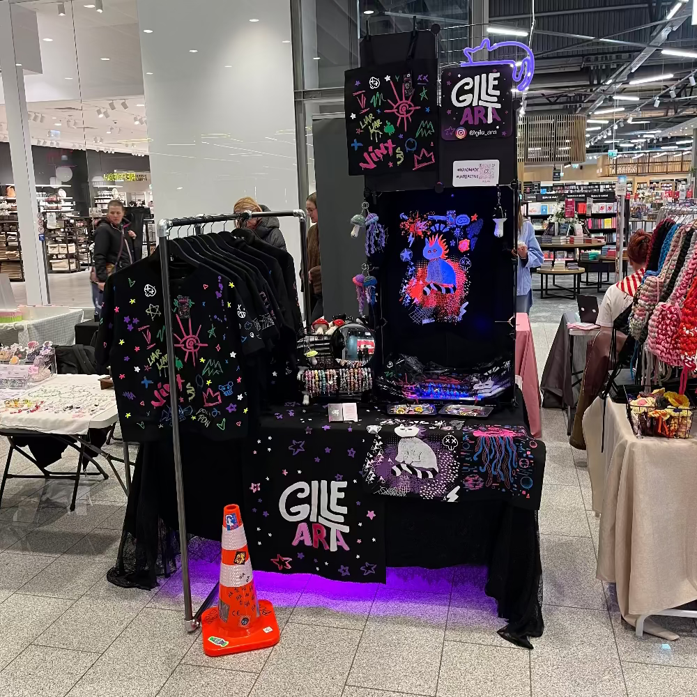 Gileara display in a store setting with colorful artwork and branded merchandise.
