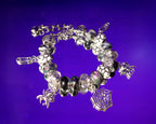 Bracelet with spider and web charms on a purple background