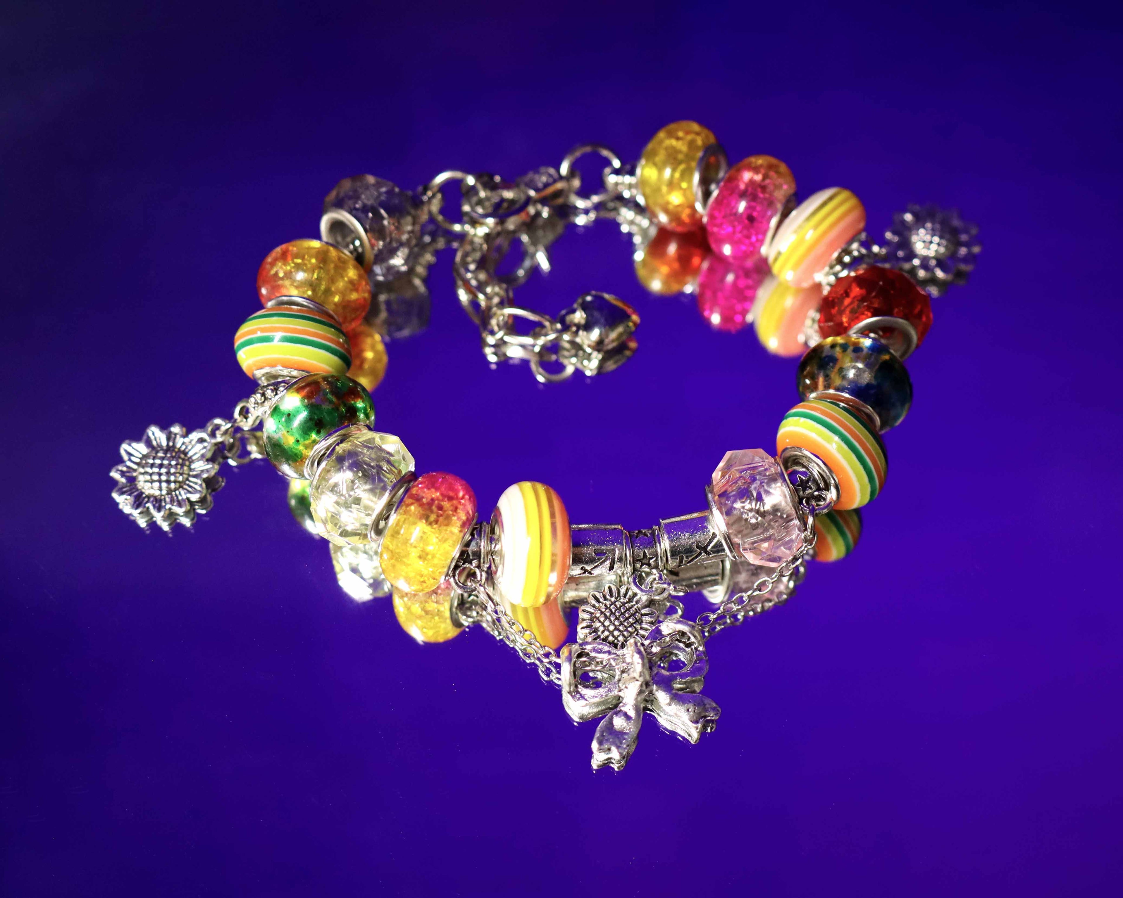 Colorful beaded bracelet with charms on a purple background