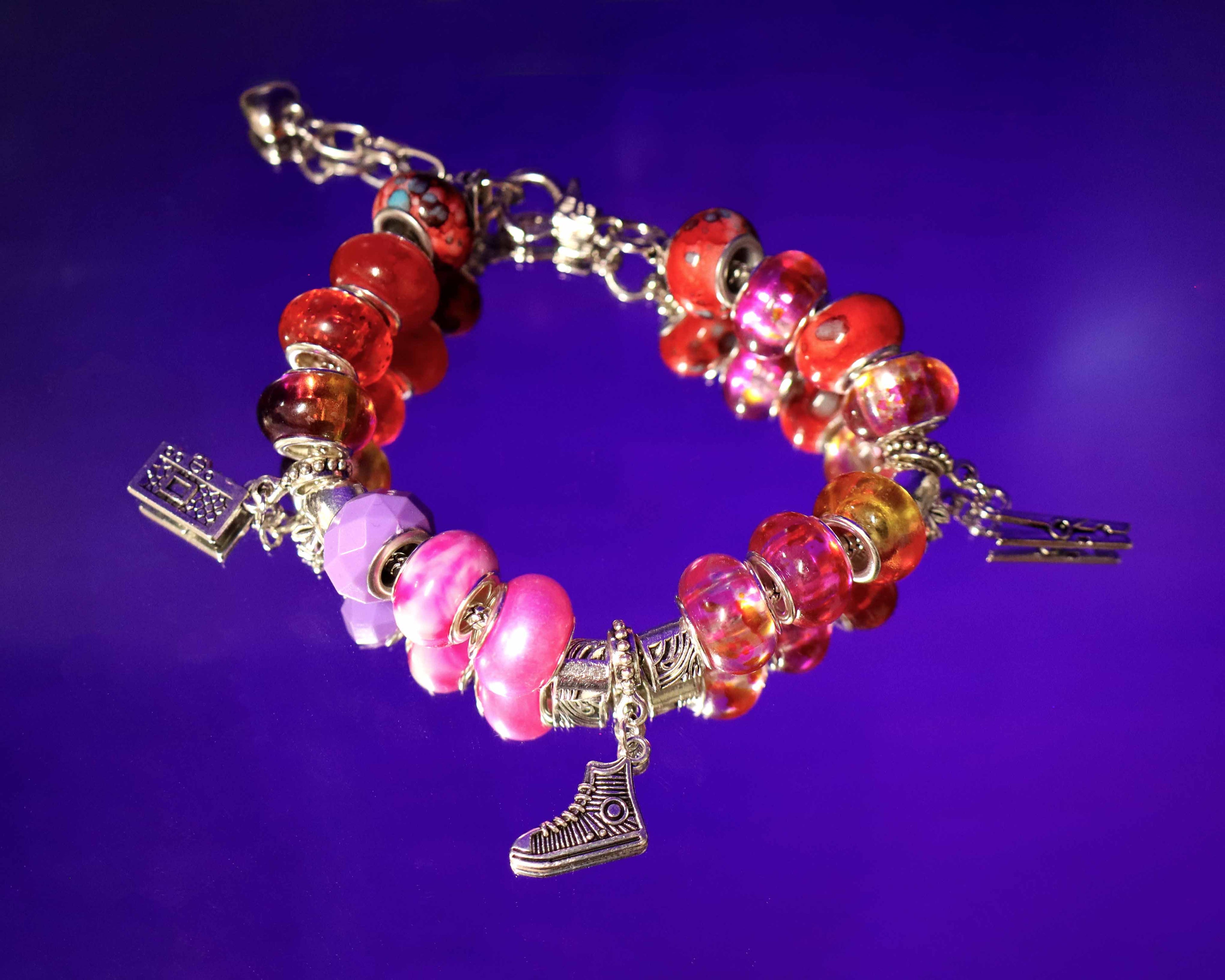 Bracelet with colorful beads and charms on a purple background