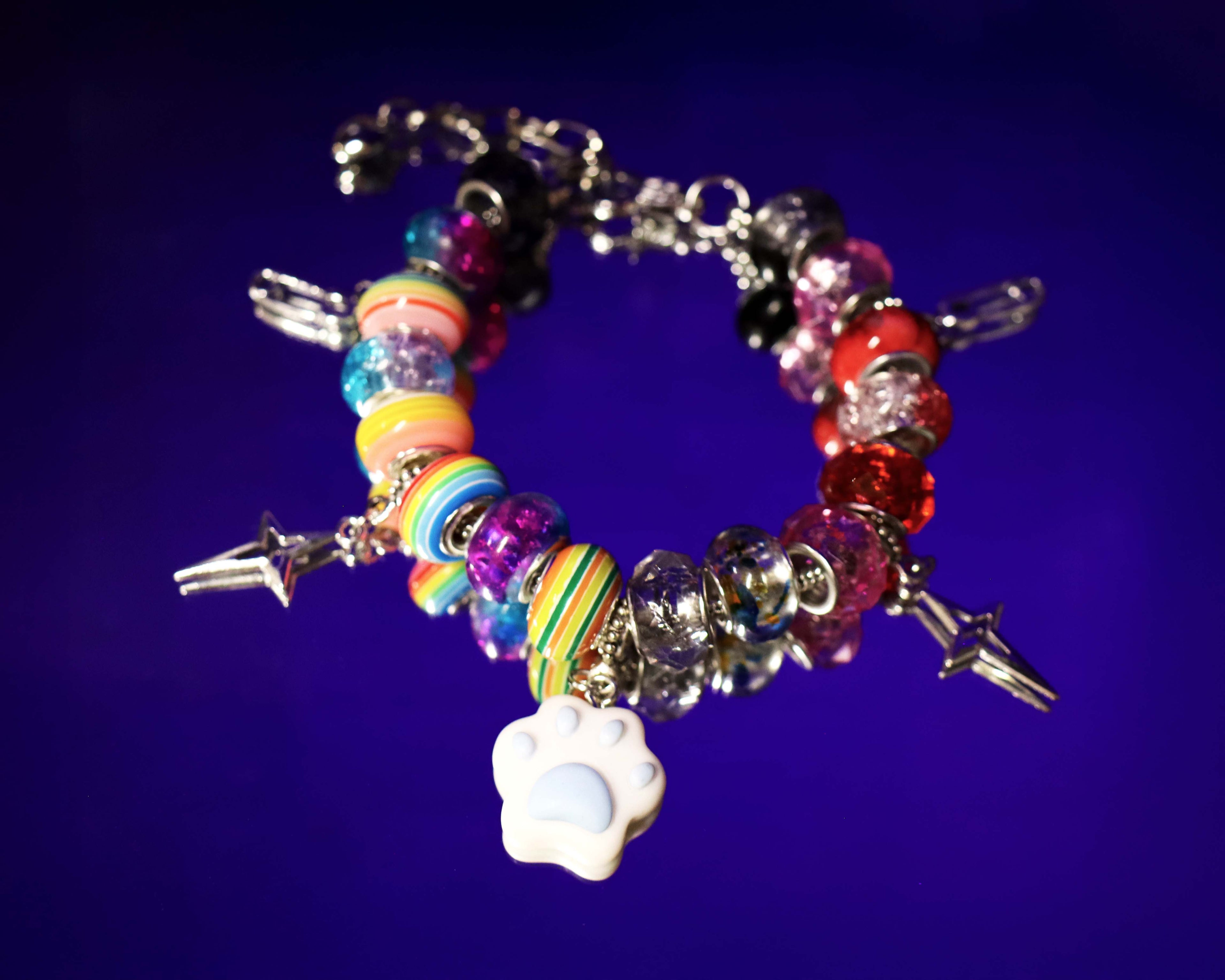 Colorful beaded bracelet with charms on a dark blue background