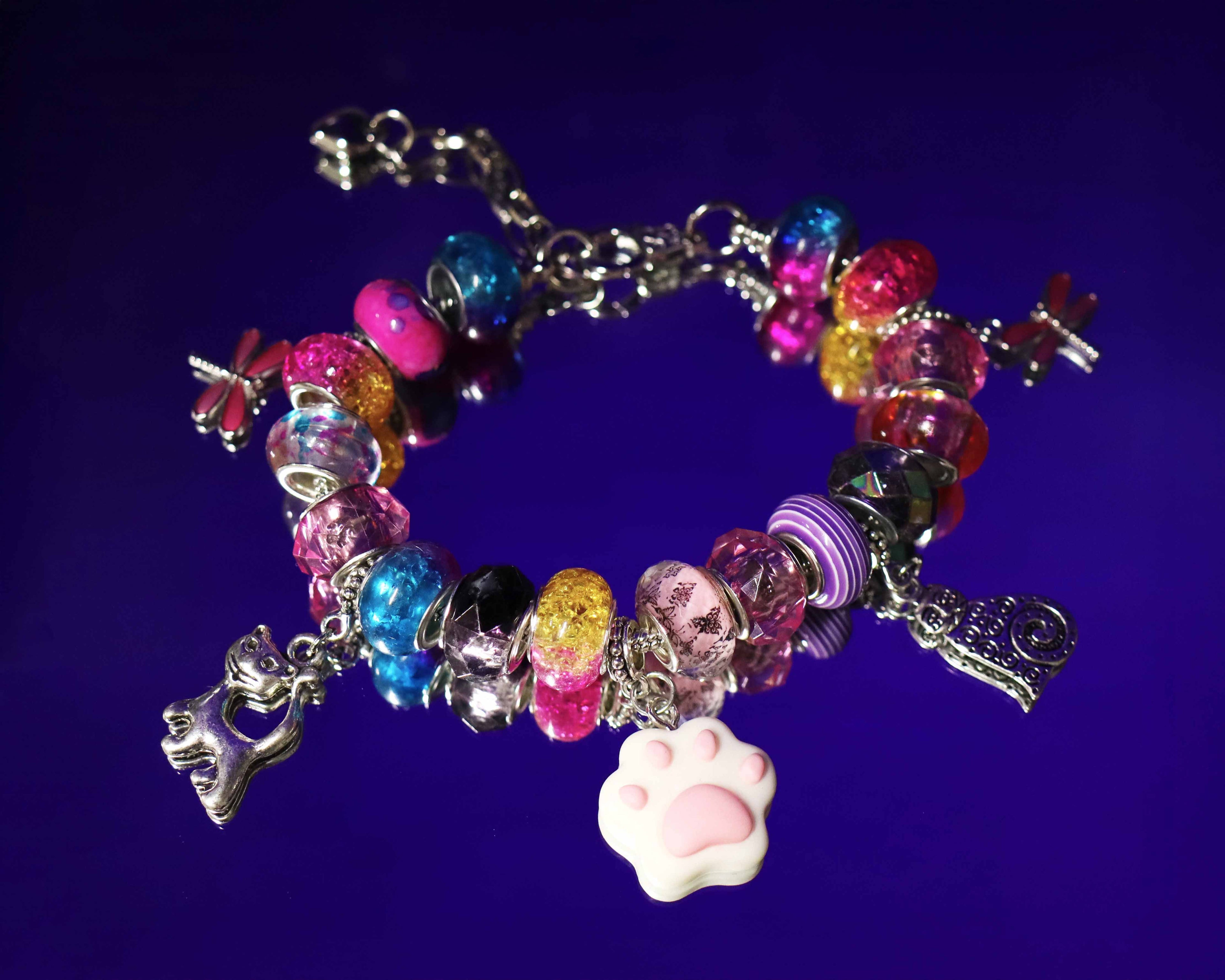 Colorful beaded bracelet with charms on a dark purple background