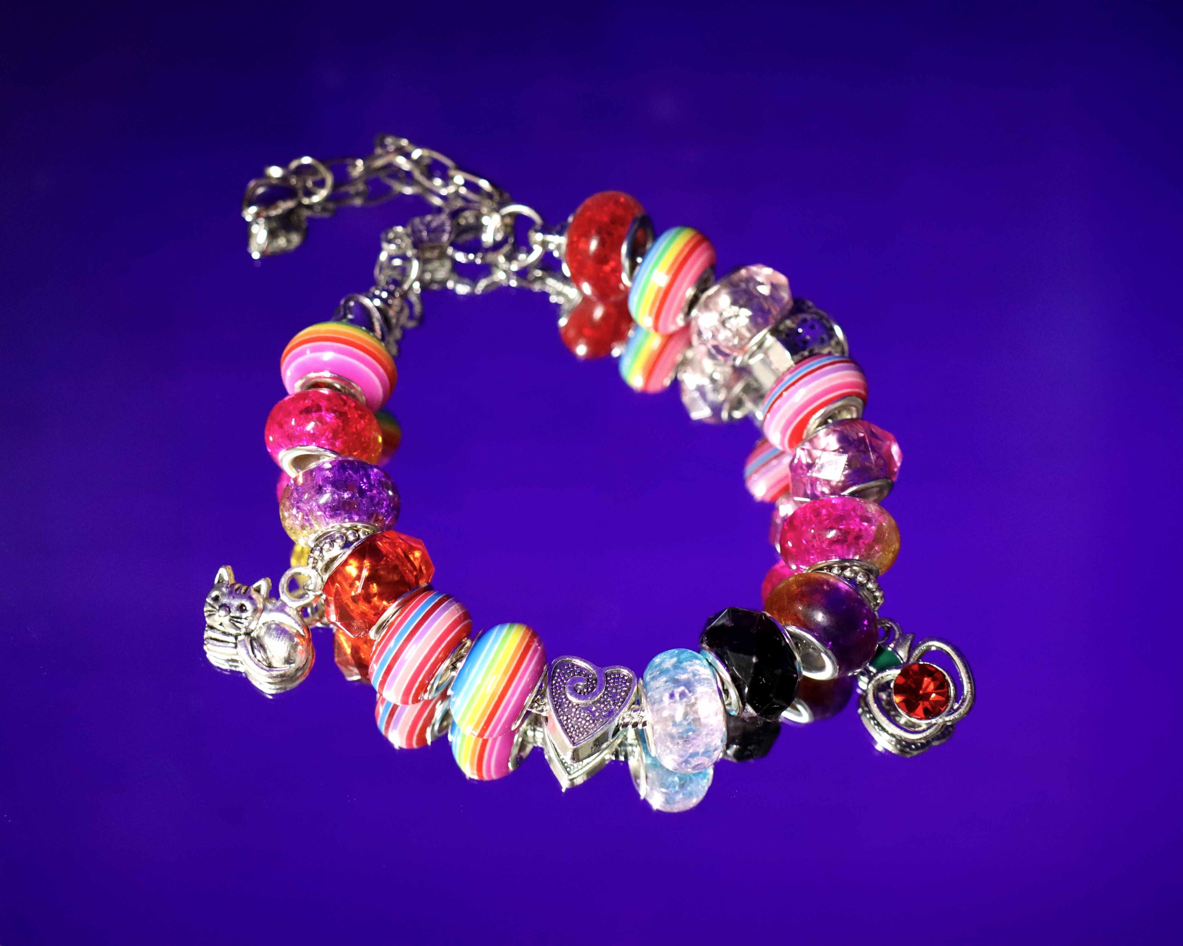 Colorful beaded bracelet with charms on a purple background