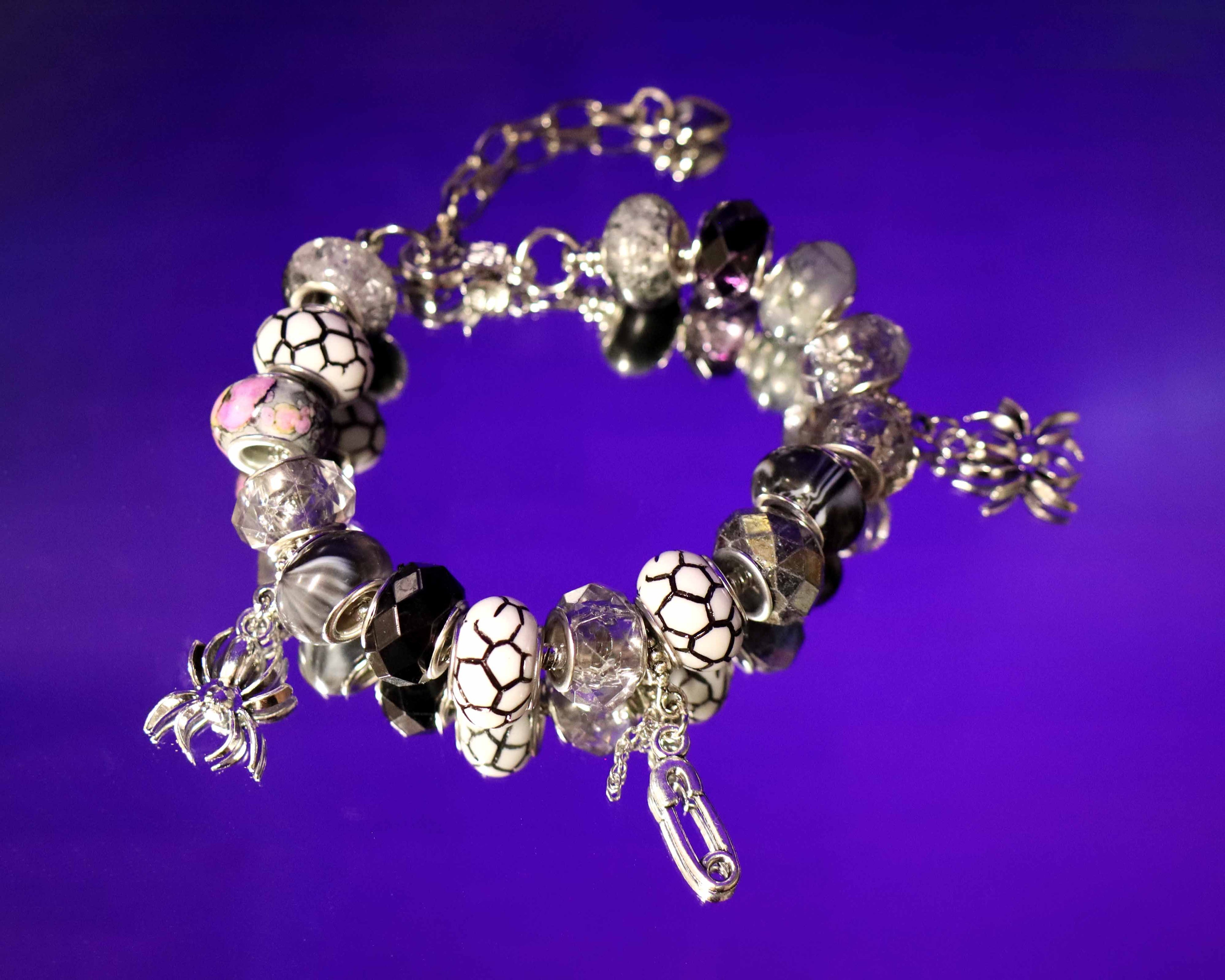 Bracelet with various beads and charms on a purple background