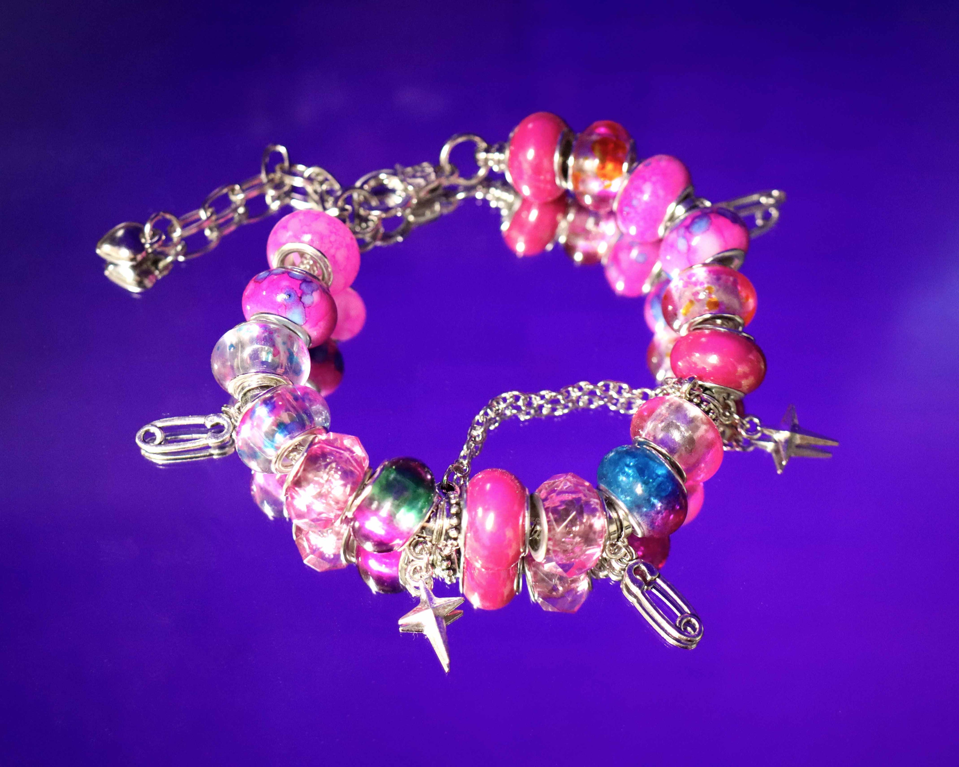 Colorful beaded bracelet with charms on a purple background
