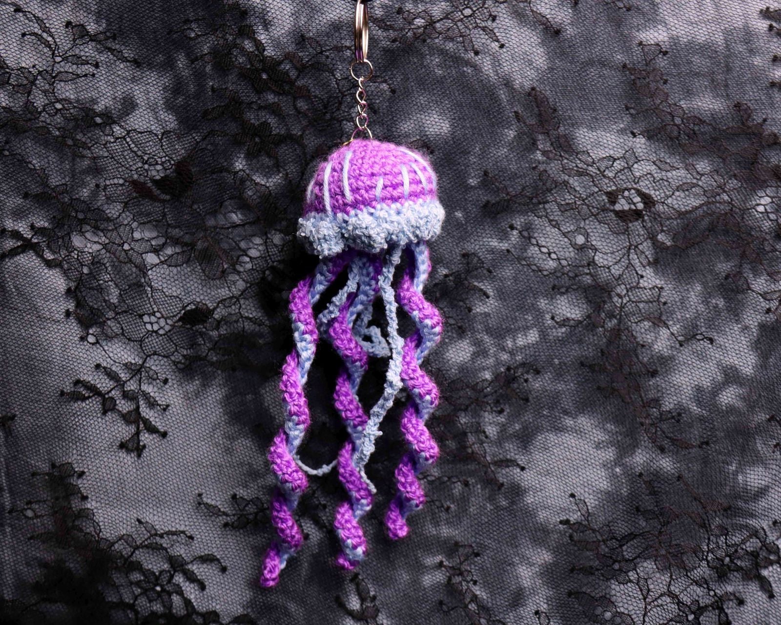 Crocheted jellyfish pendant on a dark textured background