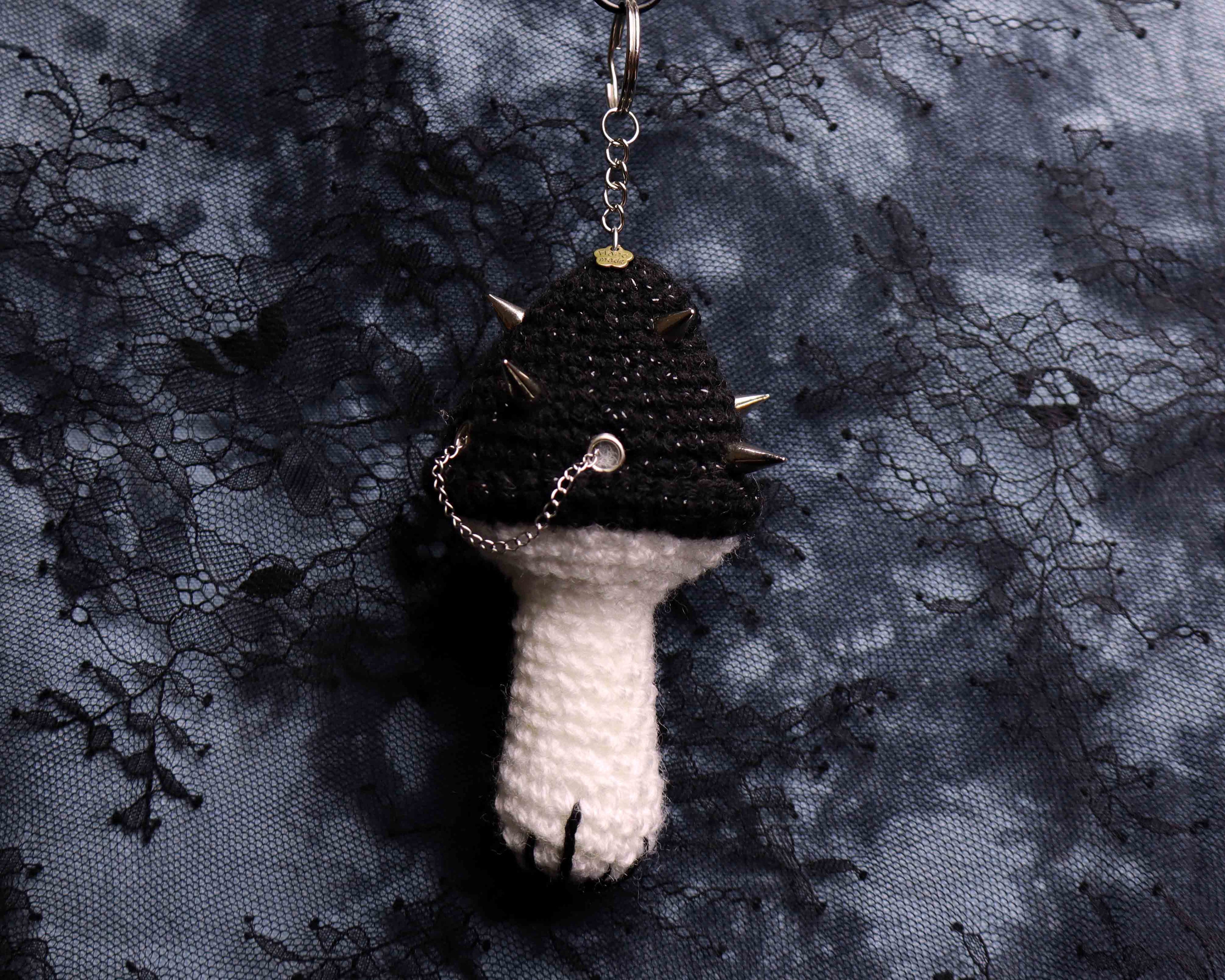 Textured keychain with spiky top on a dark lace background