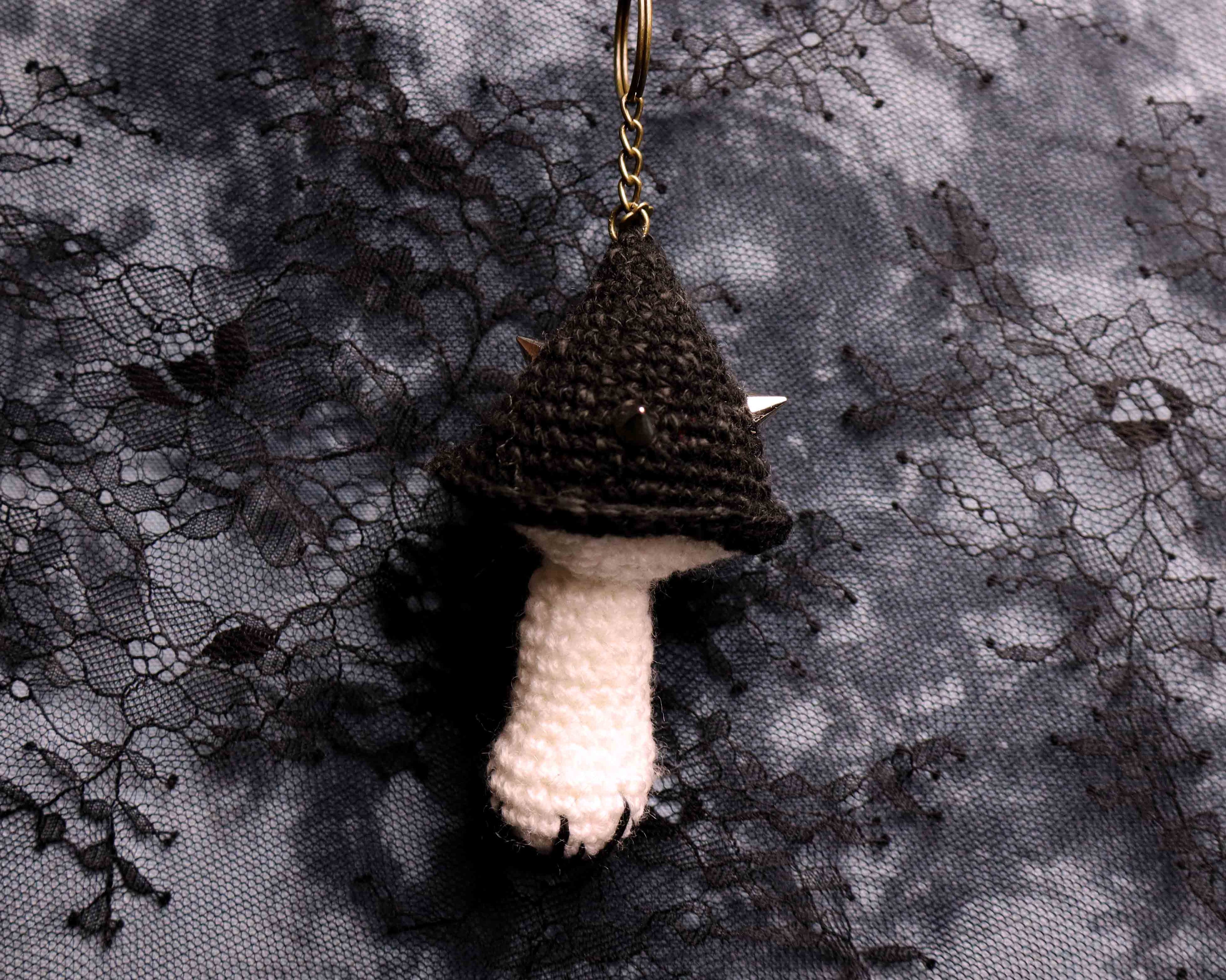 Crocheted mushroom ornament on a textured fabric background