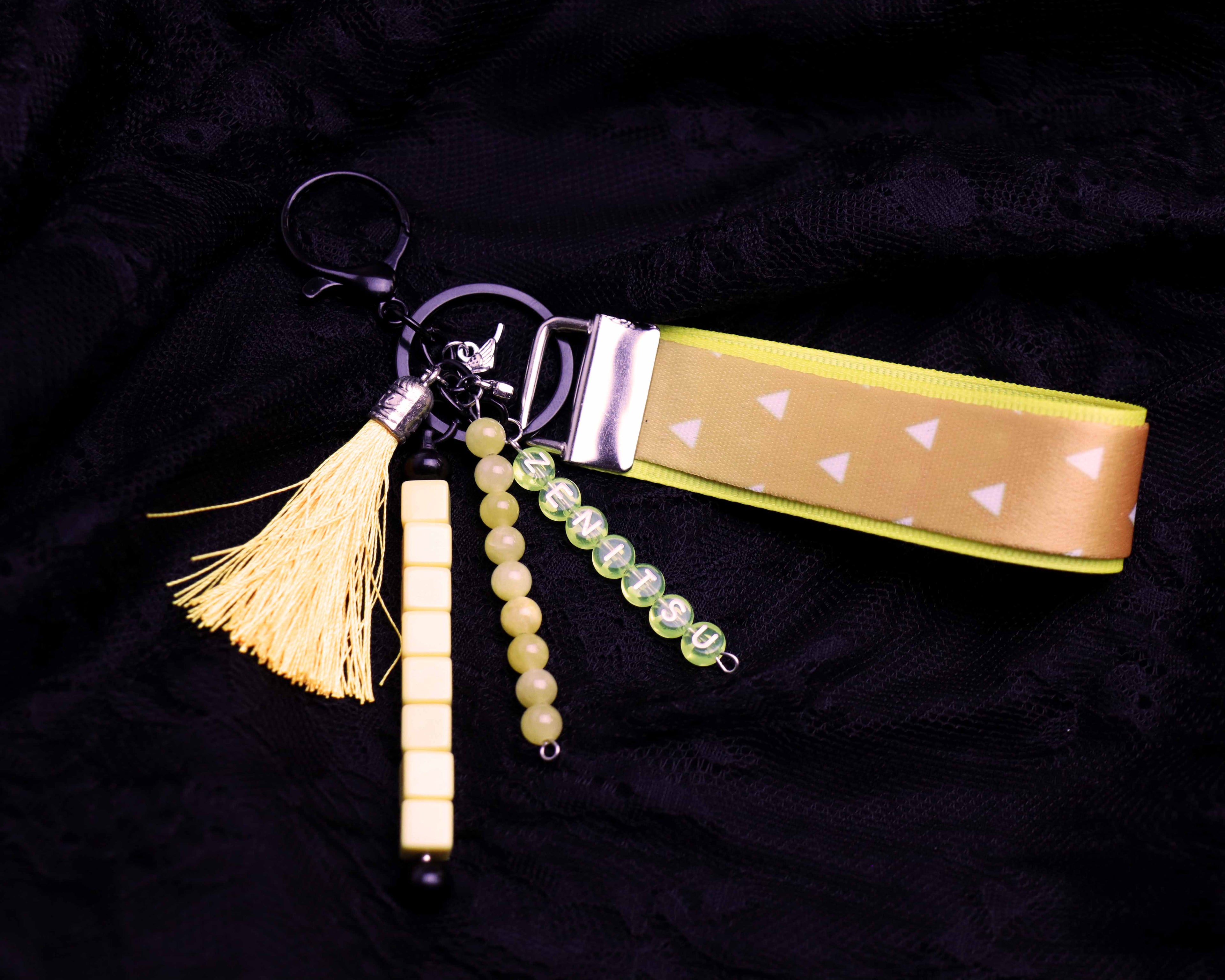 Keychain with tassel, beads, and patterned strap on a dark background