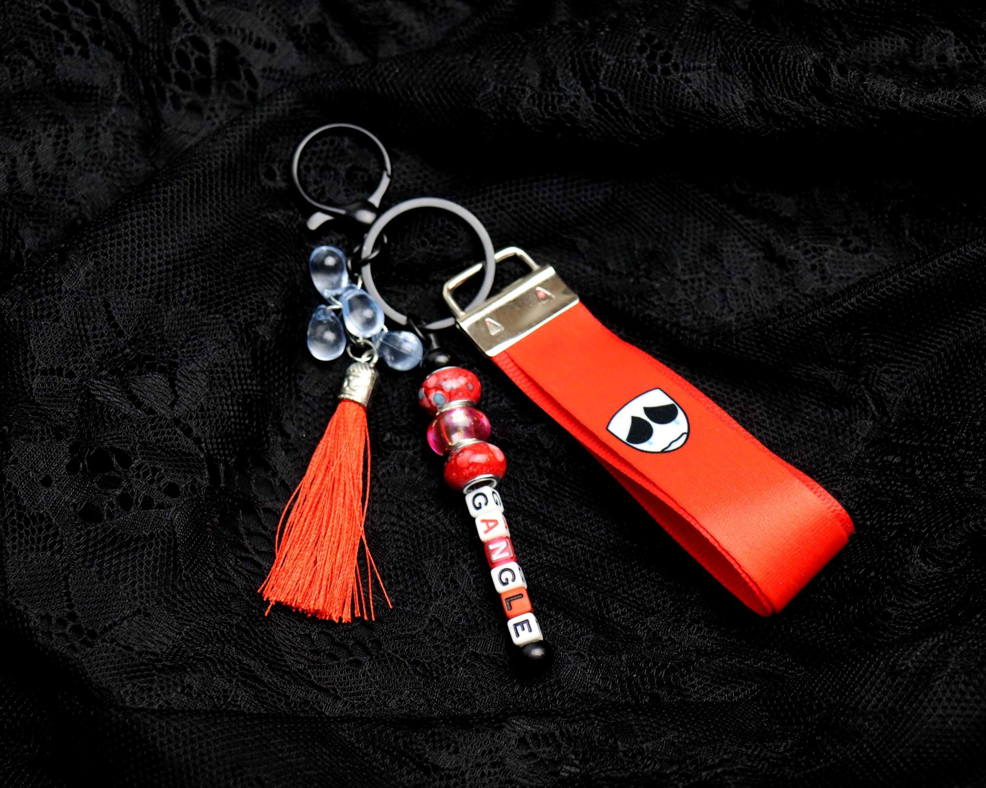 Keychain with red tassel and decorative elements on a black background
