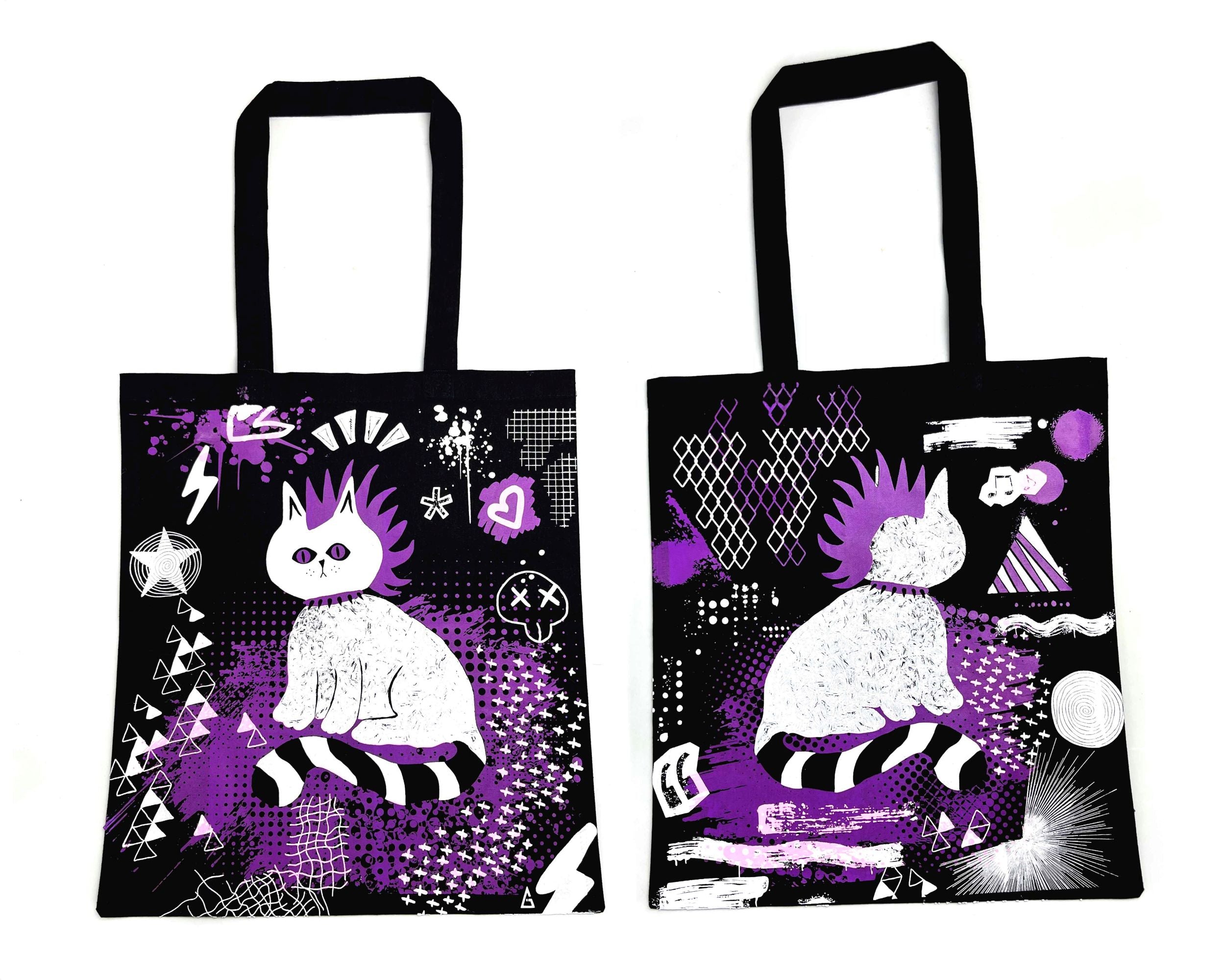 Two tote bags with a stylized cat design on a black background